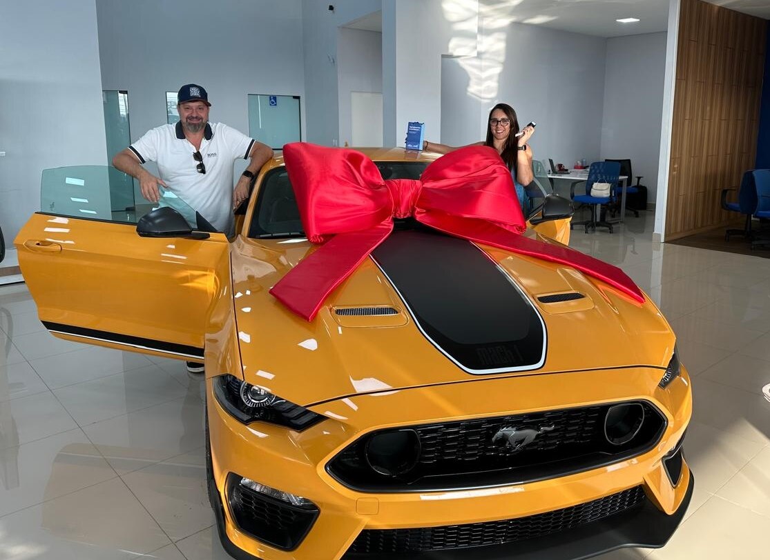 Angélica e seu marido Carlos na entrega do Mustang Mach 1 na concessionária